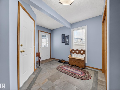 Entryway featuring tile flooring, a window providing natural light, and a white paneled door - 7 85 Gervais Road, St. Albert, AB - Indoor Photo Showing Other Room