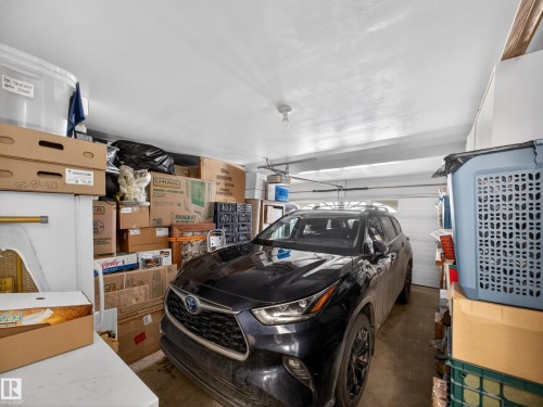 The property includes an enclosed garage with a white overhead door and concrete flooring - 7 85 Gervais Road, St. Albert, AB - Indoor Photo Showing Garage