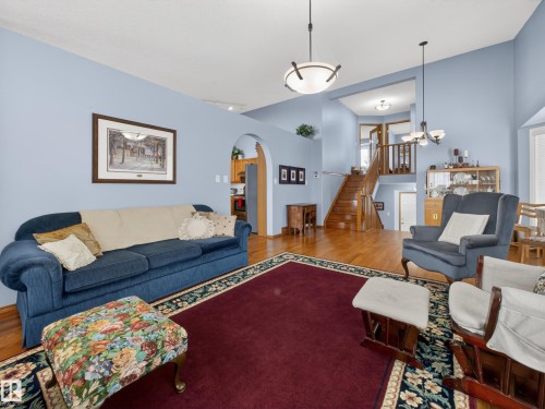 Spacious living area featuring light blue walls, hardwood flooring, and a large area rug - 7 85 Gervais Road, St. Albert, AB - Indoor Photo Showing Living Room