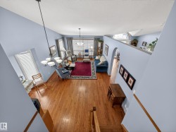 The property features an open-concept living area with hardwood flooring and light blue walls - 