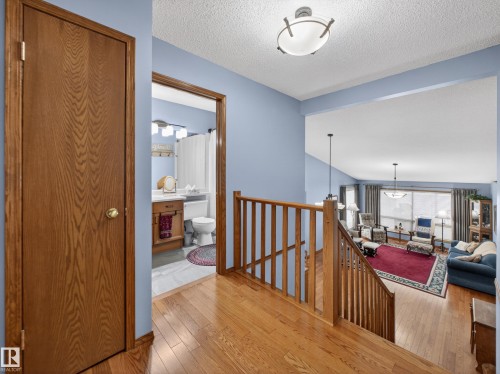 Entryway with hardwood flooring and a view into a living area with large windows - 7 85 Gervais Road, St. Albert, AB - Indoor Photo Showing Other Room