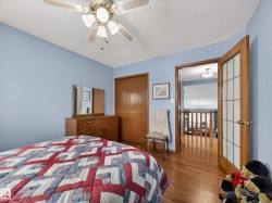 The property features hardwood floors, a ceiling fan, and a wood-paneled closet - 