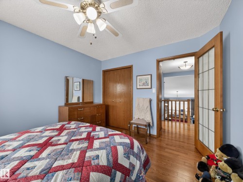 The property features hardwood floors, a ceiling fan, and a wood-paneled closet - 7 85 Gervais Road, St. Albert, AB - Indoor Photo Showing Bedroom