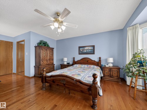 This inviting bedroom features hardwood flooring and light blue walls, creating a serene atmosphere - 7 85 Gervais Road, St. Albert, AB - Indoor Photo Showing Bedroom