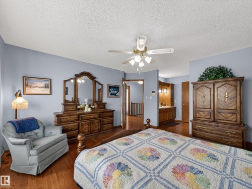 This room features hardwood flooring, light blue walls, and a ceiling fan with integrated lighting - 7 85 Gervais Road, St. Albert, AB - Indoor Photo Showing Bedroom