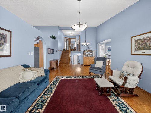 The property features a bright living area with light blue walls, hardwood flooring, and an arched doorway - 7 85 Gervais Road, St. Albert, AB - Indoor