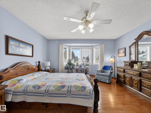 This room features hardwood flooring, a ceiling fan, and light blue walls - 7 85 Gervais Road, St. Albert, AB - Indoor Photo Showing Bedroom