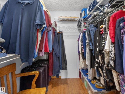 The property features a closet with wire shelving and wood-look flooring - 7 85 Gervais Road, St. Albert, AB - Indoor With Storage
