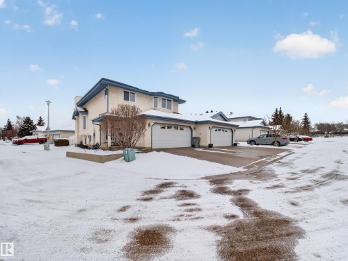 The property features a light-colored exterior with a blue roof, offering a distinctive architectural style - 7 85 Gervais Road, St. Albert, AB - Outdoor