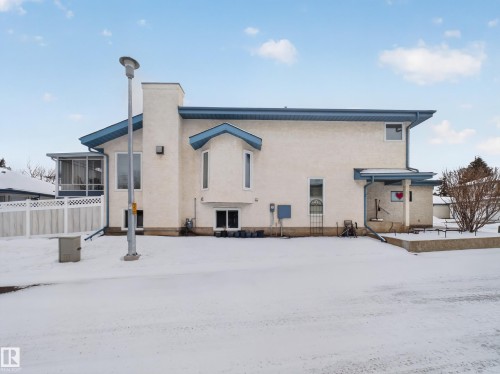 The property features a stucco exterior, a screened-in porch, and blue trim accents - 7 85 Gervais Road, St. Albert, AB - Outdoor