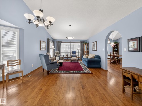 The living area features hardwood floors, vaulted ceilings, and an arched doorway leading to an adjoining space - 7 85 Gervais Road, St. Albert, AB - Indoor