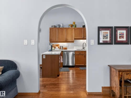 Kitchen featuring wooden cabinetry, stainless steel appliances, a white subway tile backsplash, and a white countertop - 7 85 Gervais Road, St. Albert, AB - Indoor Photo Showing Other Room