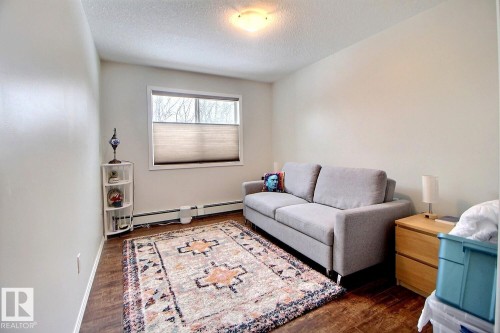 This room features a window with blinds, hardwood flooring, and white painted walls - 114 592 Hooke Road, Edmonton, AB - Indoor