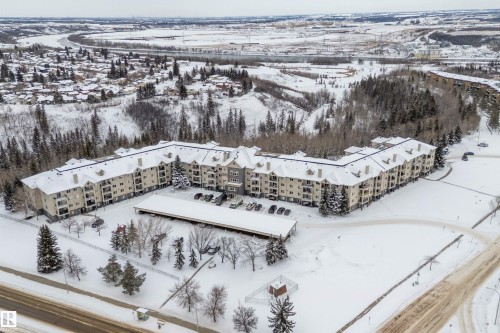 This multi-story property features a large building with balconies, surrounded by a snow-covered landscape - 114 592 Hooke Road, Edmonton, AB - Outdoor With View