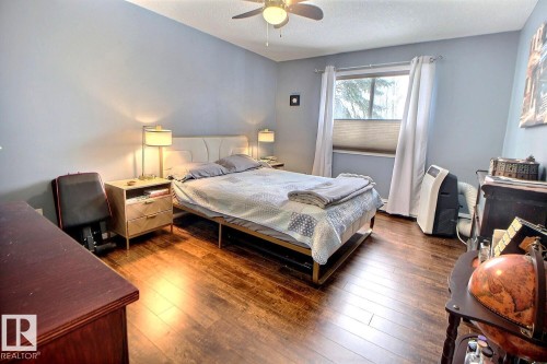 This room features hardwood flooring, a window with blinds, and light blue walls - 114 592 Hooke Road, Edmonton, AB - Indoor Photo Showing Bedroom