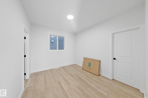 This room features light-colored flooring, white walls, and a window providing natural light - 6449 28 Avenue, Edmonton, AB - Indoor Photo Showing Other Room