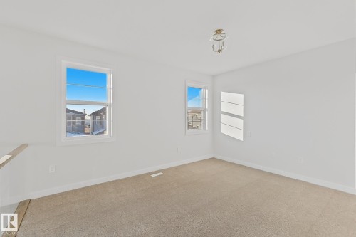 The property features a bright room with carpeted flooring and white walls - 6449 28 Avenue, Edmonton, AB - Indoor Photo Showing Other Room