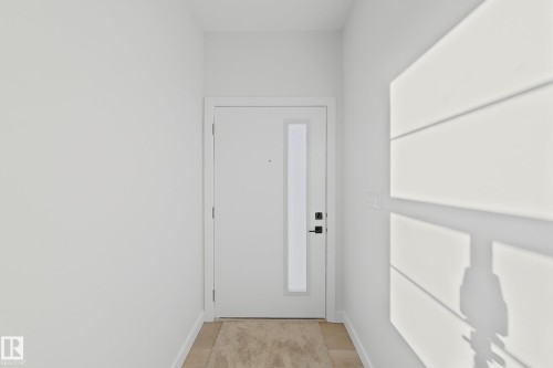 Entryway featuring a white door with a vertical glass insert, a black handle, and light-colored flooring - 6449 28 Avenue, Edmonton, AB - Indoor Photo Showing Other Room