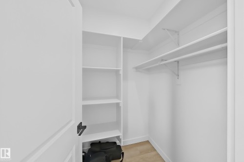 This property features a walk-in closet with built-in shelving and hanging rods, providing ample storage solutions - 6449 28 Avenue, Edmonton, AB - Indoor With Storage