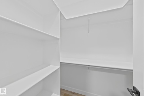 The property features a spacious closet with white shelving and hanging rods, providing ample storage space - 6449 28 Avenue, Edmonton, AB - Indoor With Storage
