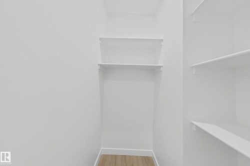 Storage area featuring white walls, light-colored flooring, and white shelving units - 6449 28 Avenue, Edmonton, AB - Indoor Photo Showing Other Room