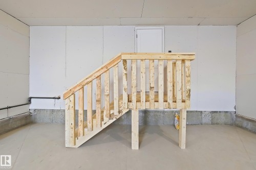 The unfinished basement features exposed stud walls and a wooden staircase - 6449 28 Avenue, Edmonton, AB - Indoor Photo Showing Other Room