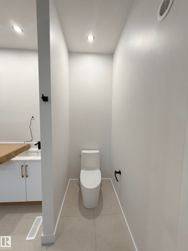 This bathroom features a contemporary toilet, recessed lighting, and tiled flooring - 6449 28 Avenue, Edmonton, AB - Indoor Photo Showing Other Room
