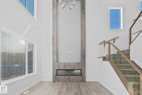 The living area features high ceilings, large windows providing natural light, and light-toned flooring - 6449 28 Avenue, Edmonton, AB - Indoor Photo Showing Other Room