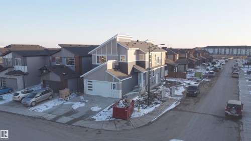 This property features a modern architectural style with a light gray and dark gray exterior, including horizontal and vertical siding details - 6449 28 Avenue, Edmonton, AB - Outdoor