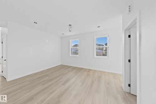 This bright room features two windows, light-toned flooring, and recessed lighting, offering a versatile space - 6449 28 Avenue, Edmonton, AB - Indoor Photo Showing Other Room