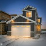 The property features a dark grey exterior with white trim, a double garage with frosted glass panels, and stone detailing around the base - 803 30 Avenue, Edmonton, AB  - Outdoor 