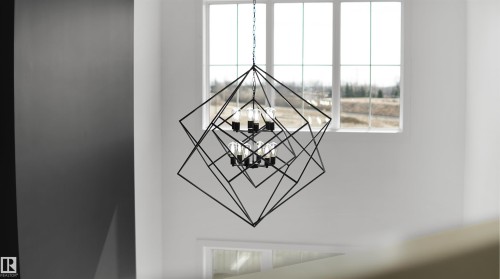 A striking geometric chandelier illuminates the space, featuring large windows that provide abundant natural light and views of the surrounding landscape - 803 30 Avenue, Edmonton, AB - Indoor Photo Showing Other Room