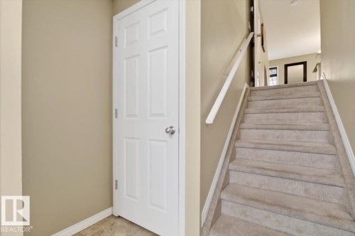 The property features a staircase with carpeted treads and a handrail - 1637 Towne Centre Boulevard, Edmonton, AB - Indoor Photo Showing Other Room