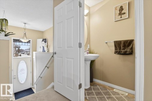 Entryway with an overhead light fixture, a door featuring an oval window, and a white handrail - 1637 Towne Centre Boulevard, Edmonton, AB - Indoor Photo Showing Other Room