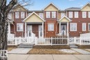 The property features a charming exterior with brown siding and brick accents, complemented by white window frames and white picket fencing - 1637 Towne Centre Boulevard, Edmonton, AB  - Outdoor With Facade 