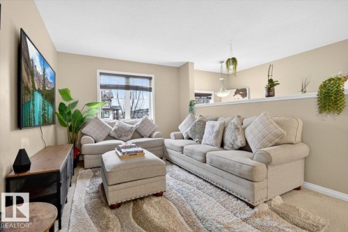 This inviting living area features neutral-toned walls, a window with blinds, and a plush area rug - 1637 Towne Centre Boulevard, Edmonton, AB - Indoor Photo Showing Living Room
