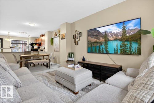 Spacious living area featuring a large window, light-colored walls, and a view into the kitchen and dining area - 1637 Towne Centre Boulevard, Edmonton, AB - Indoor Photo Showing Living Room