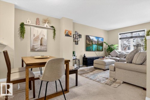The inviting living area features warm-toned walls, comfortable carpeting, and a window with blinds providing natural light - 1637 Towne Centre Boulevard, Edmonton, AB - Indoor Photo Showing Living Room