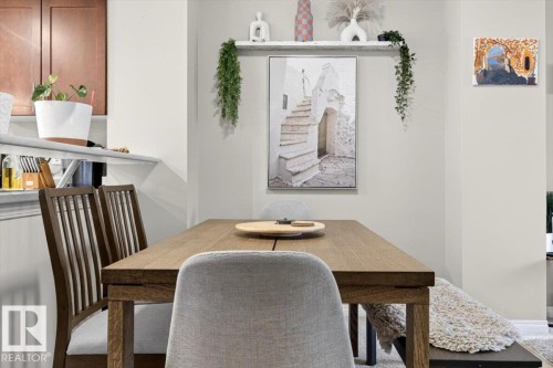 This dining area features a wooden table with seating, light-colored walls, and a decorative shelf - 1637 Towne Centre Boulevard, Edmonton, AB - Indoor Photo Showing Dining Room