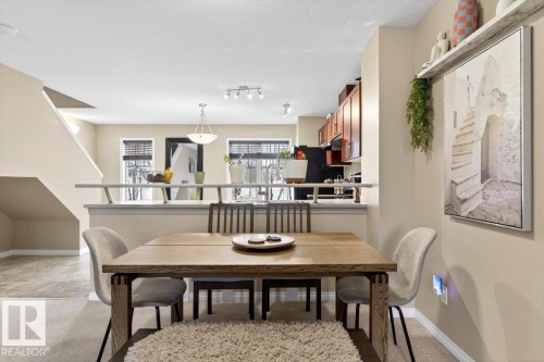 The dining area features light-colored walls and carpet flooring, with a wooden table and chairs - 1637 Towne Centre Boulevard, Edmonton, AB - Indoor Photo Showing Dining Room