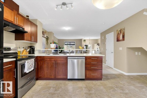 The kitchen features wood cabinetry, stainless steel appliances, and a light-colored countertop - 1637 Towne Centre Boulevard, Edmonton, AB - Indoor Photo Showing Kitchen With Double Sink