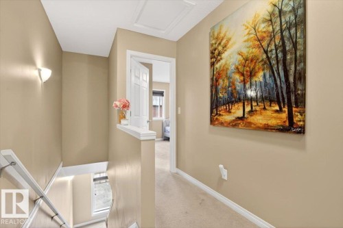 The property features a staircase with white railings, beige walls, and light-colored carpeting - 1637 Towne Centre Boulevard, Edmonton, AB - Indoor Photo Showing Other Room