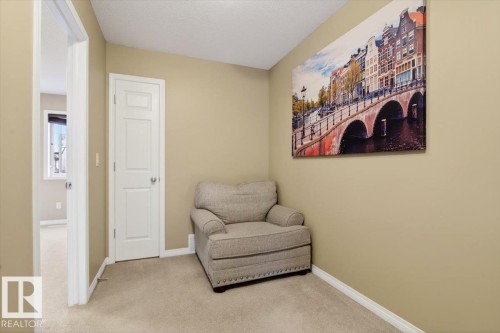 This room features light-colored carpet, a white paneled door, and neutral-toned walls - 1637 Towne Centre Boulevard, Edmonton, AB - Indoor Photo Showing Other Room