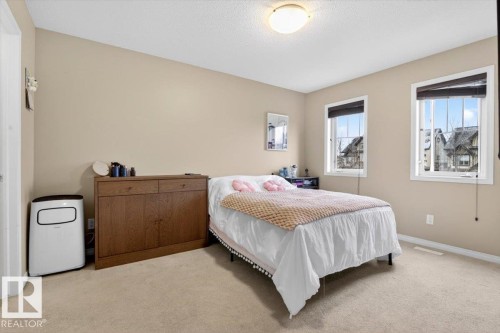 Bedroom featuring neutral colored walls, carpeting, and two windows providing natural light - 1637 Towne Centre Boulevard, Edmonton, AB - Indoor Photo Showing Bedroom