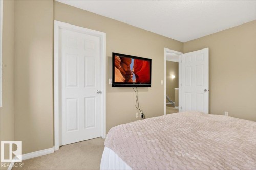 This room features neutral-toned walls, a wall-mounted television, and carpeted flooring - 1637 Towne Centre Boulevard, Edmonton, AB - Indoor Photo Showing Bedroom