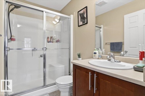 Bathroom featuring a shower with sliding glass doors, a vanity with a light-colored countertop, and a mirror - 1637 Towne Centre Boulevard, Edmonton, AB - Indoor Photo Showing Bathroom