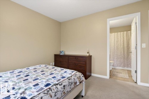 Bedroom with neutral-toned walls and carpeted flooring, featuring a dark wood dresser - 1637 Towne Centre Boulevard, Edmonton, AB - Indoor Photo Showing Bedroom
