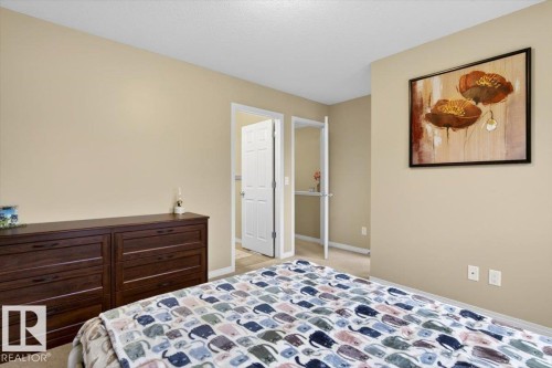 This room features neutral-toned walls, light-colored carpeting, and a white door with a paneled design - 1637 Towne Centre Boulevard, Edmonton, AB - Indoor Photo Showing Bedroom