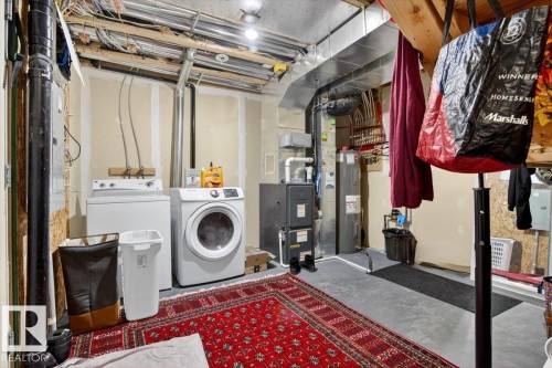 This property includes a utility area featuring a washer and dryer, a water heater, and an exposed ceiling - 1637 Towne Centre Boulevard, Edmonton, AB - Indoor Photo Showing Laundry Room