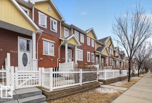 The property features a charming exterior with a white picket fence, a front porch, and steps leading to the entrance - 1637 Towne Centre Boulevard, Edmonton, AB - Outdoor With Facade